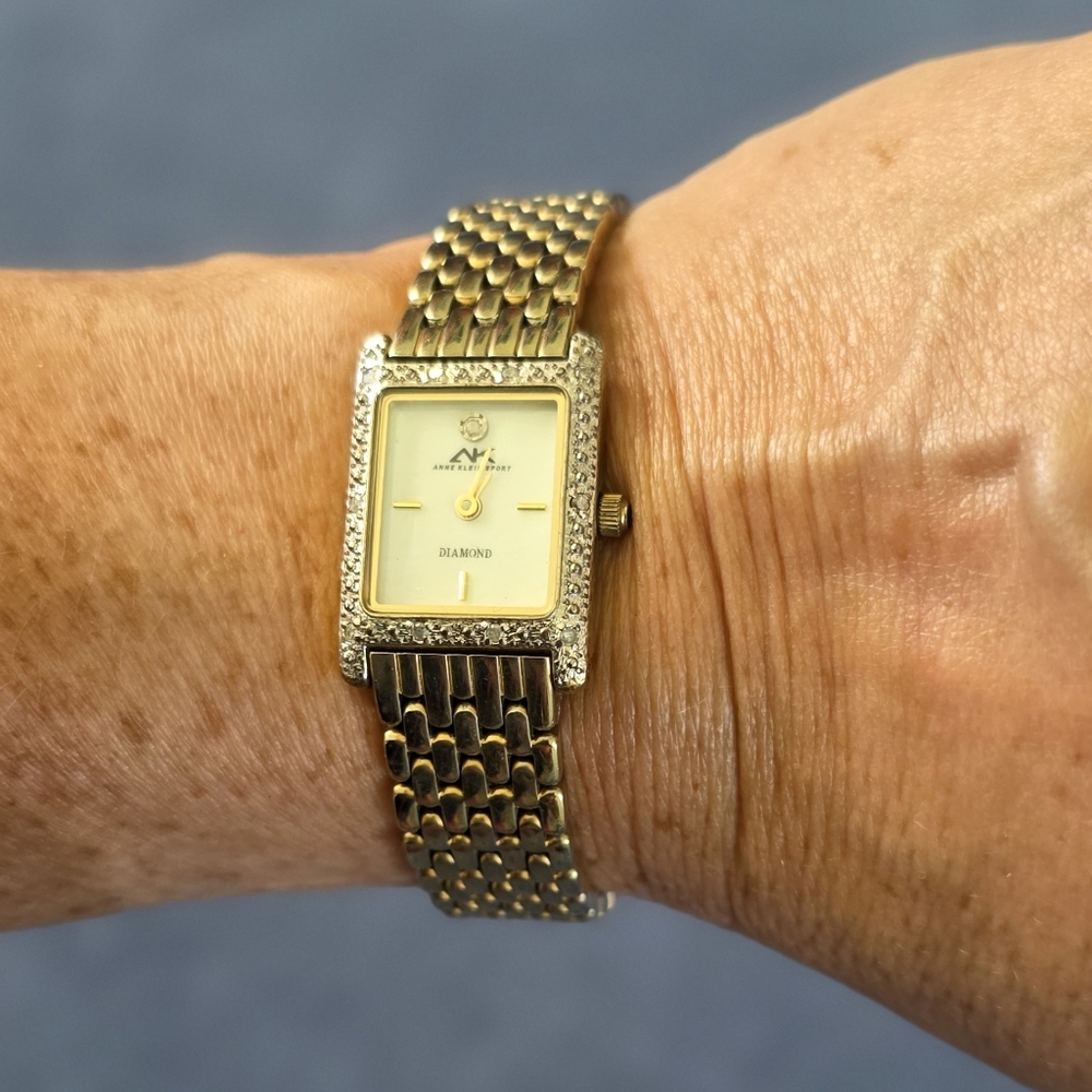 Ann Klein gold tone watch with diamond accents, mother of pearl face